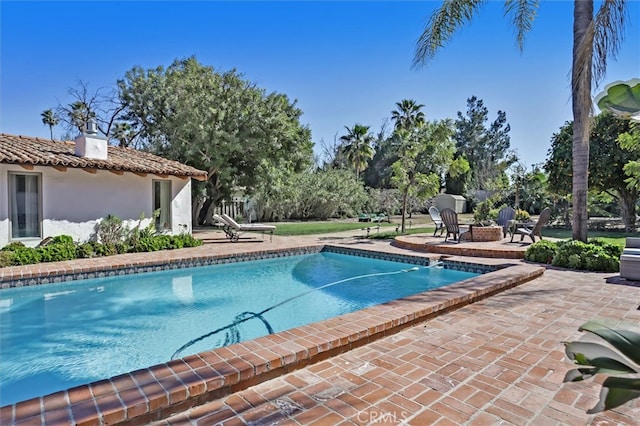 view of swimming pool with a patio area and an outdoor fire pit