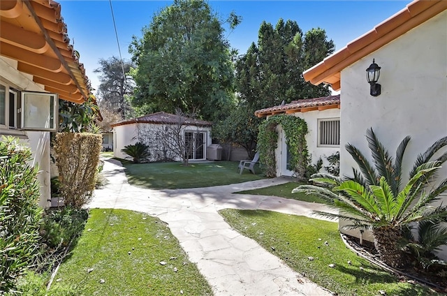 view of yard featuring a patio and an outbuilding