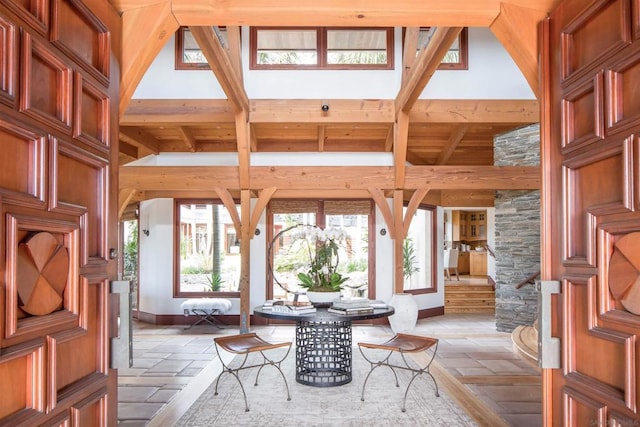 foyer with beam ceiling and high vaulted ceiling