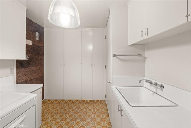 laundry area featuring cabinets, washer / clothes dryer, and sink