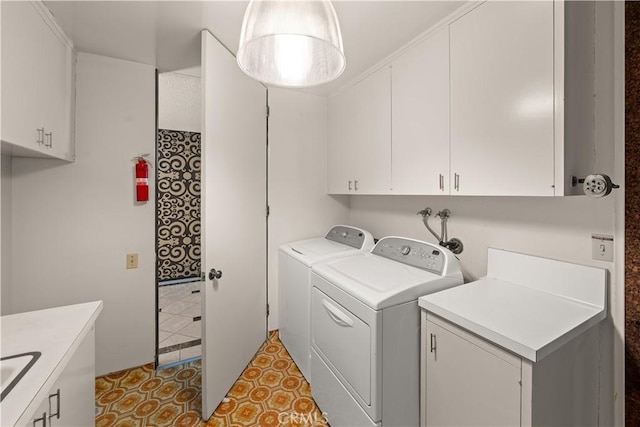 clothes washing area featuring washer and dryer and cabinets