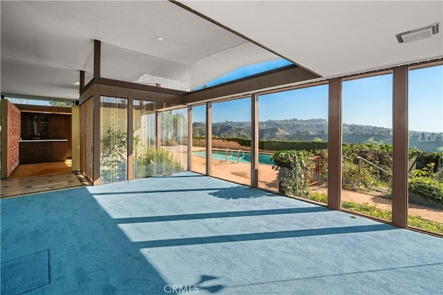 unfurnished sunroom featuring a mountain view and plenty of natural light