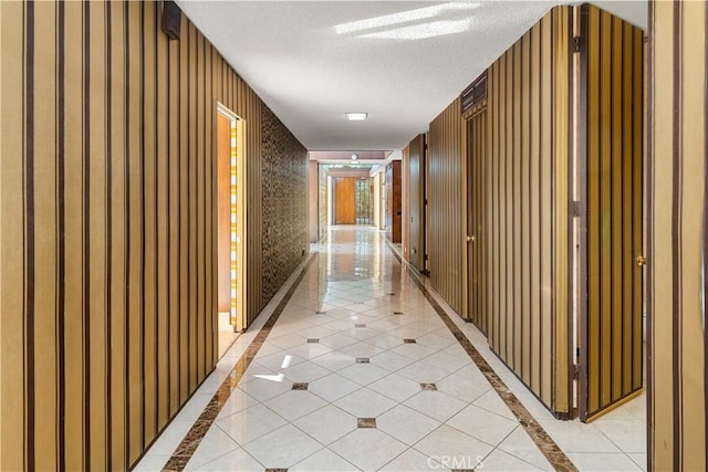 1470 Laurel Way, Beverly Hills, CA 90210 - hallway featuring inlaid floor details, wallpapered walls, a textured ceiling, and light tile patterned floors
