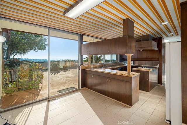 1470 Laurel Way, Beverly Hills, CA 90210 - kitchen featuring freestanding refrigerator, a sink, a peninsula, light tile patterned floors, and premium range hood
