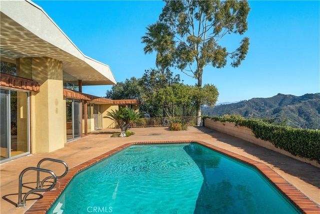 view of swimming pool featuring a mountain view and a patio