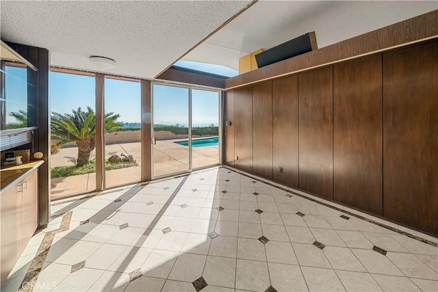 1470 Laurel Way, Beverly Hills, CA 90210 - unfurnished room featuring inlaid floor details, expansive windows, light tile patterned flooring, and a textured ceiling