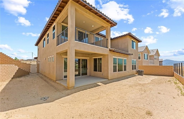 rear view of property with a mountain view and a patio area