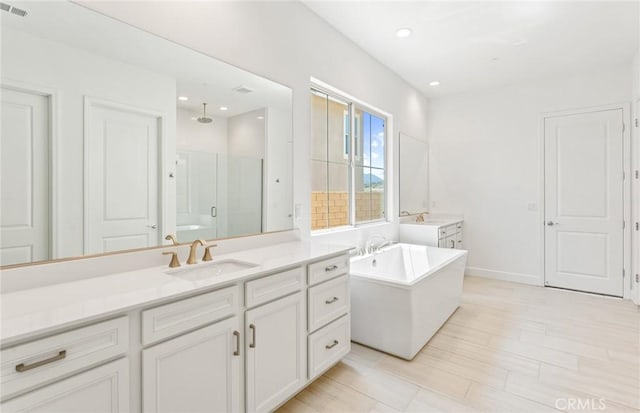 bathroom featuring hardwood / wood-style floors, vanity, and independent shower and bath