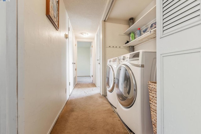 clothes washing area featuring washer and dryer and light carpet