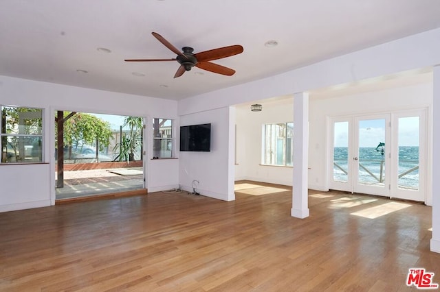 unfurnished living room with light wood-type flooring and ceiling fan