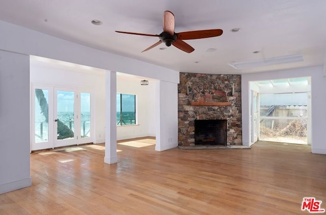 unfurnished living room with light hardwood / wood-style flooring, ceiling fan, and a fireplace