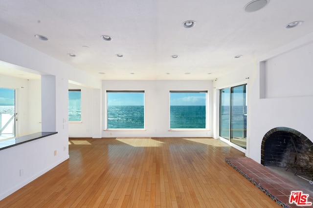 unfurnished living room featuring a brick fireplace and hardwood / wood-style flooring