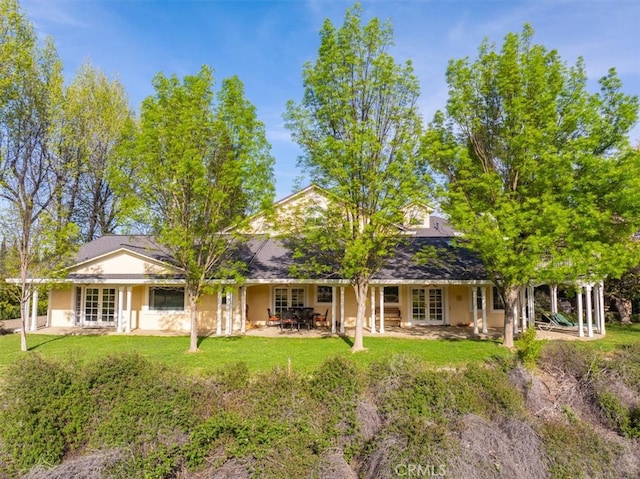 back of house with a lawn and a patio