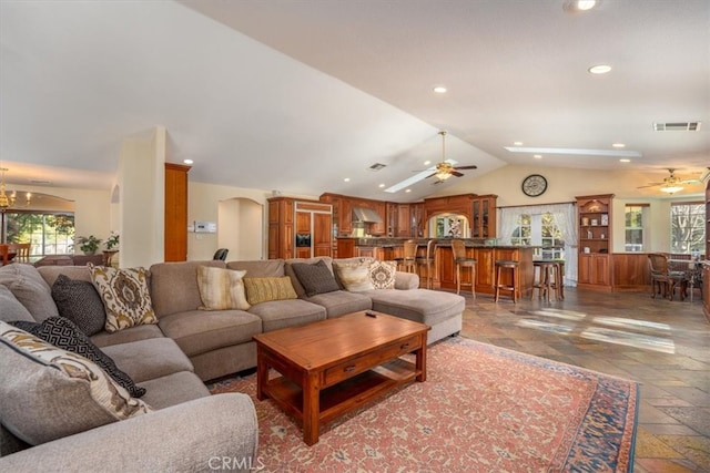 living room featuring vaulted ceiling, ceiling fan, and a wealth of natural light