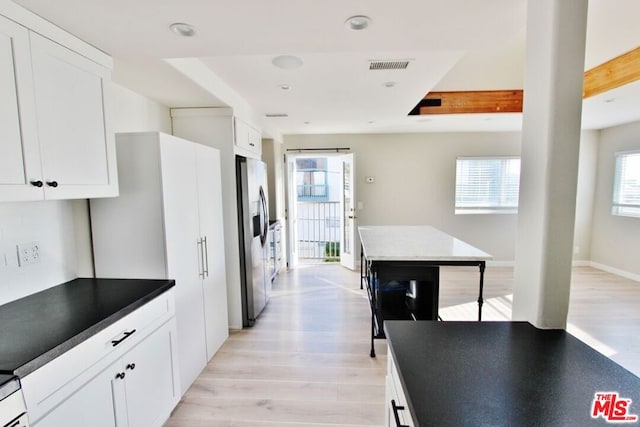 kitchen with stainless steel fridge with ice dispenser, light wood-type flooring, and white cabinets