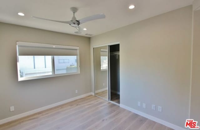 unfurnished bedroom with a closet, ceiling fan, and light wood-type flooring