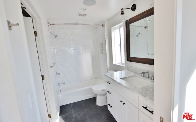 full bathroom with vanity, tiled shower / bath combo, toilet, and tile patterned flooring