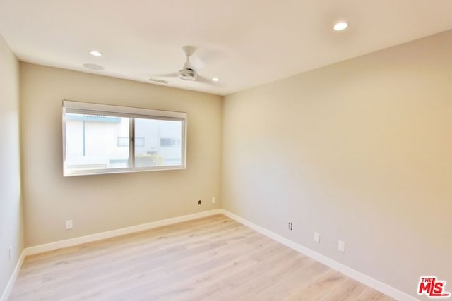 spare room featuring light hardwood / wood-style flooring and ceiling fan