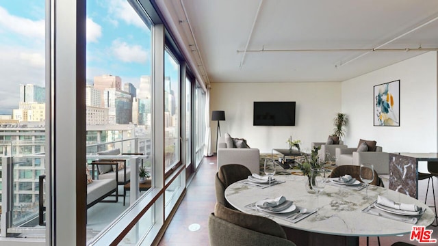 dining space with dark hardwood / wood-style flooring and a wall of windows