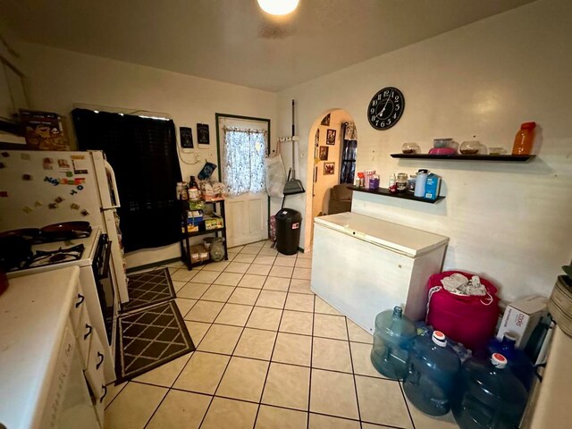 kitchen featuring light tile patterned flooring and white appliances