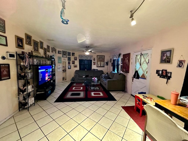 tiled living room featuring ceiling fan and rail lighting