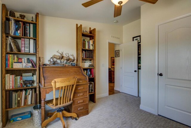 carpeted office featuring ceiling fan