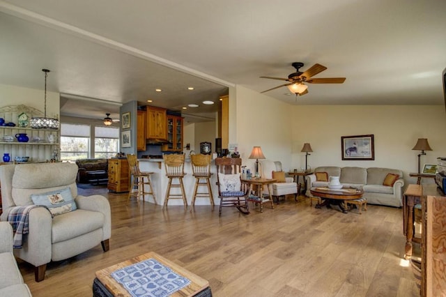 living room with ceiling fan and light hardwood / wood-style flooring