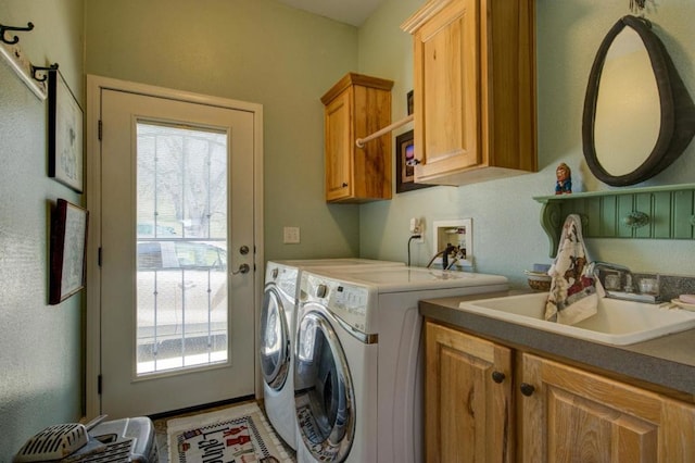 washroom with cabinets, separate washer and dryer, and sink