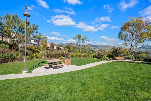 view of community with a mountain view and a lawn