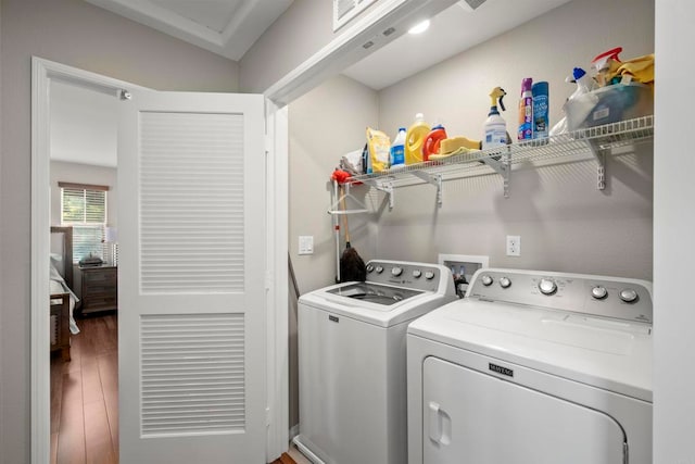 clothes washing area with washer and clothes dryer and hardwood / wood-style floors