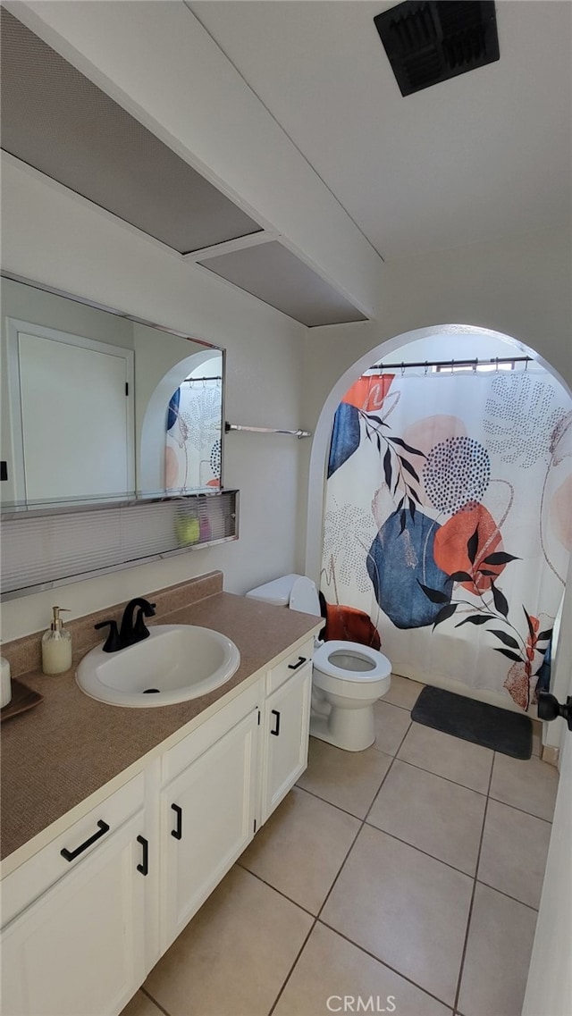 bathroom with toilet, tile patterned floors, and vanity