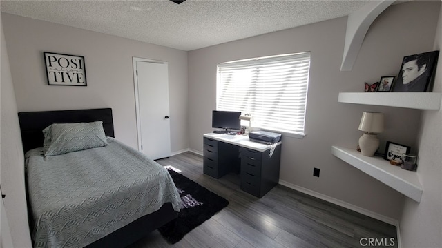 bedroom featuring wood-type flooring and a textured ceiling