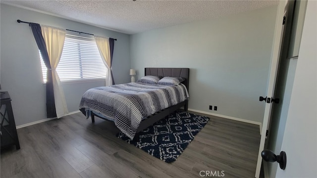 bedroom featuring dark hardwood / wood-style flooring and a textured ceiling