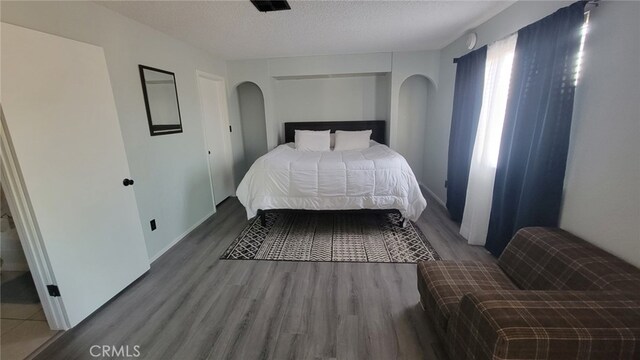 bedroom featuring a textured ceiling and hardwood / wood-style floors