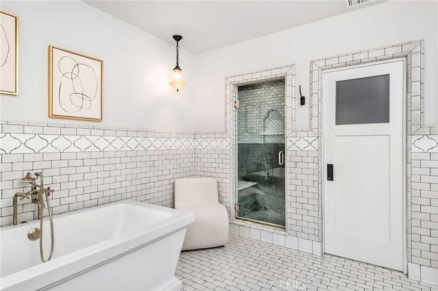 bathroom featuring plus walk in shower, tile patterned floors, and tile walls