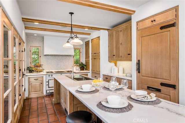 kitchen with beam ceiling, sink, tasteful backsplash, decorative light fixtures, and custom exhaust hood