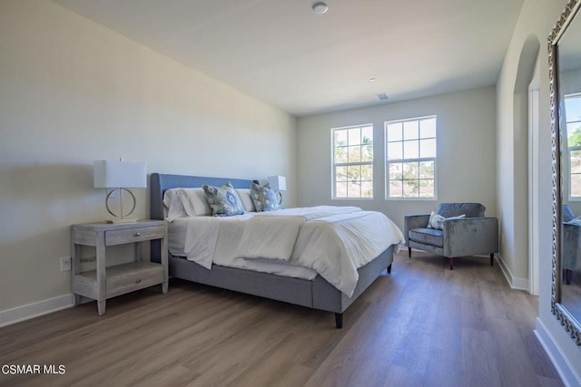 bedroom with dark hardwood / wood-style floors