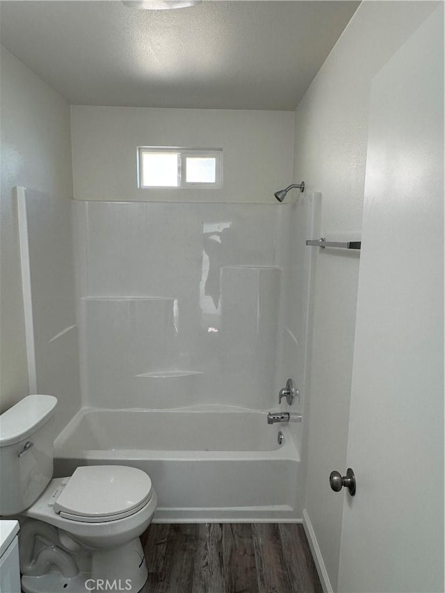 full bathroom with washtub / shower combination, toilet, wood-type flooring, a textured ceiling, and vanity