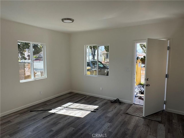 unfurnished bedroom featuring multiple windows and dark hardwood / wood-style floors