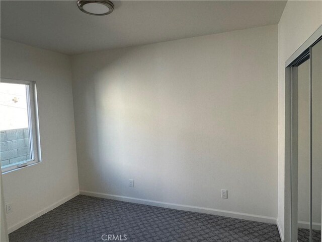 spare room with dark colored carpet