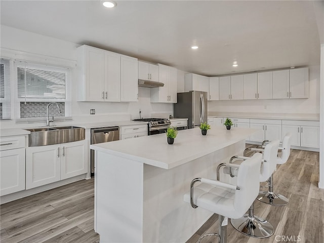143 N Hobart Blvd, Los Angeles, CA 90004 - kitchen featuring stainless steel appliances, sink, a center island, a kitchen bar, and white cabinets