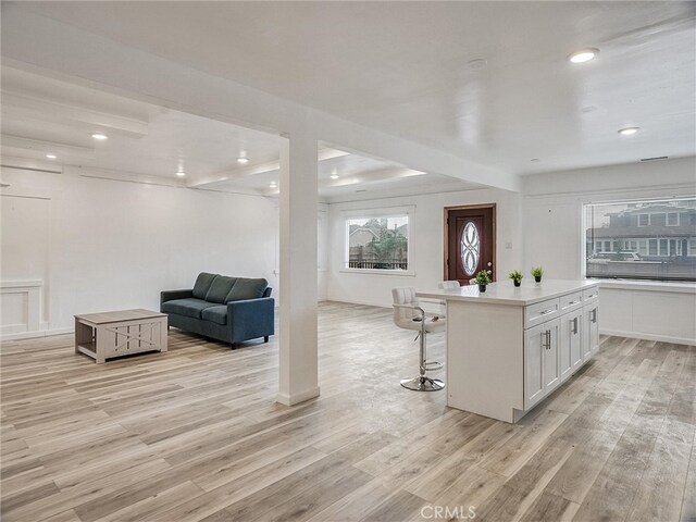 143 N Hobart Blvd, Los Angeles, CA 90004 - kitchen with a center island, white cabinets, a kitchen bar, and light hardwood / wood-style floors