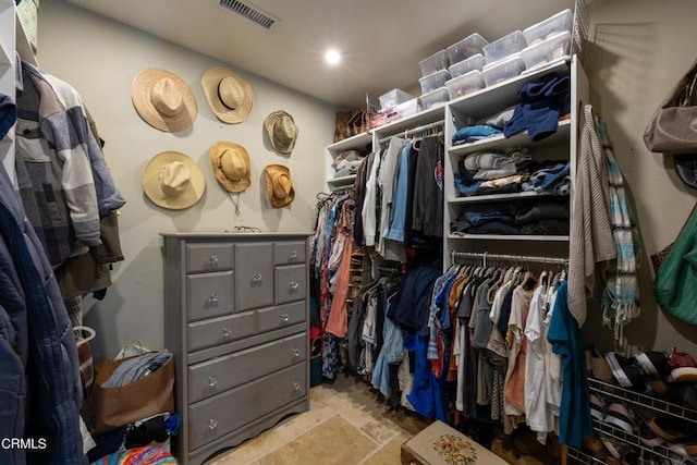 walk in closet featuring visible vents and stone finish floor