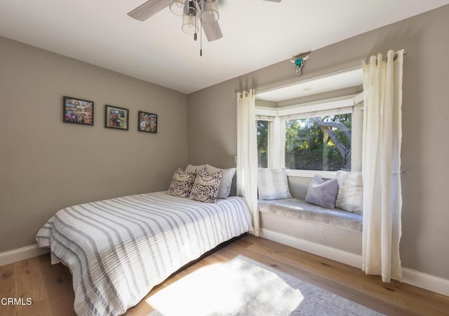 bedroom featuring baseboards, ceiling fan, and wood finished floors
