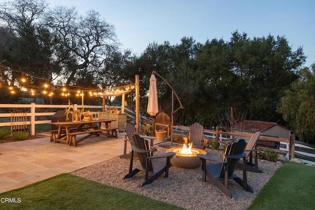 view of patio with a fire pit and fence