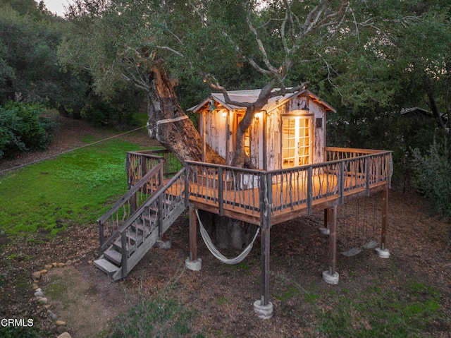 view of play area with a lawn, a deck, and stairs