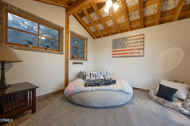 bedroom featuring lofted ceiling with beams, baseboards, and wood finished floors
