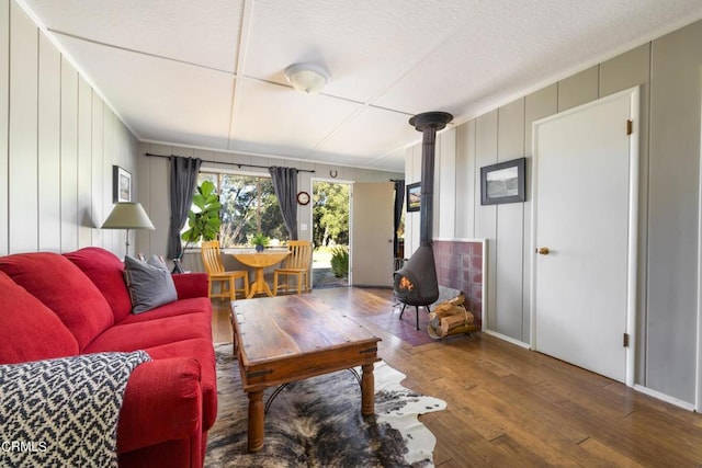 living area featuring a wood stove and wood-type flooring