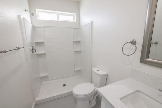 bathroom with walk in shower, vanity, and toilet