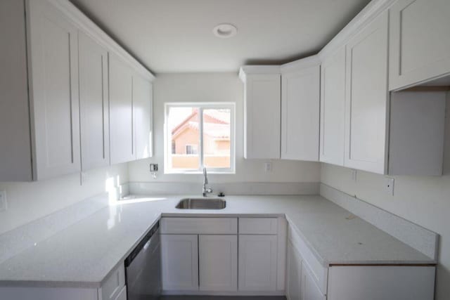 kitchen featuring dishwasher, sink, and white cabinets